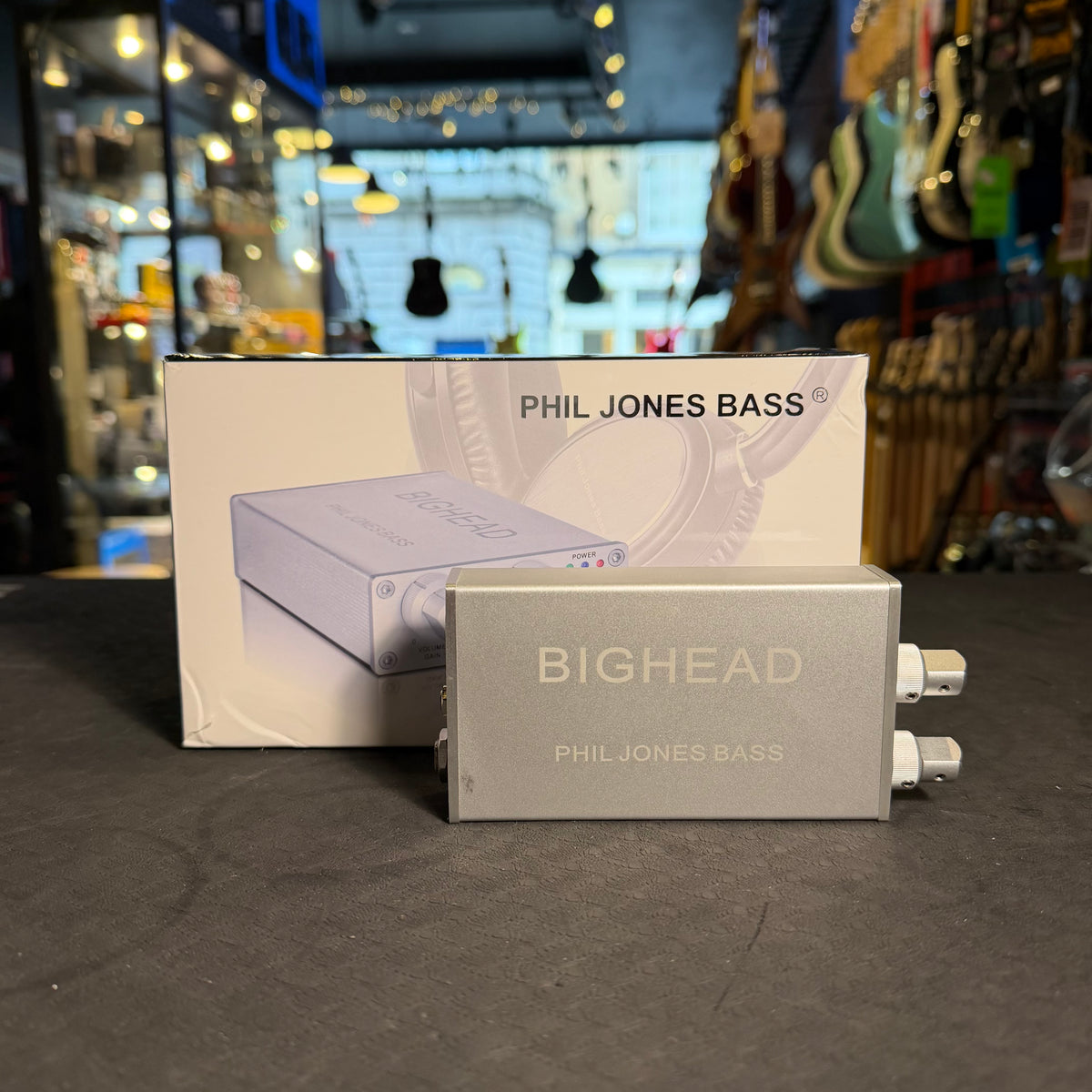 Phil Jones Bass BigHead pedal with packaging in a music store setting